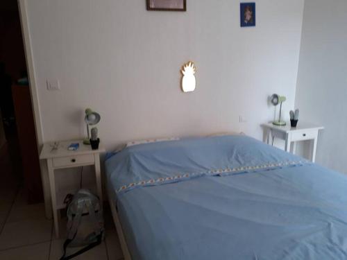 une chambre avec un lit bleu avec un sac à dos et un bureau dans l'établissement Appartement Centre Ville Saint-Raphaël, à Saint-Raphaël