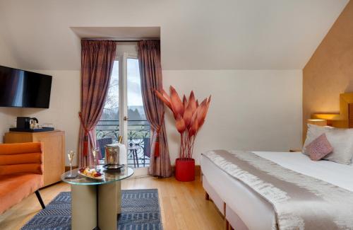 a hotel room with a bed and a glass table at La Côte Saint Jacques in Joigny