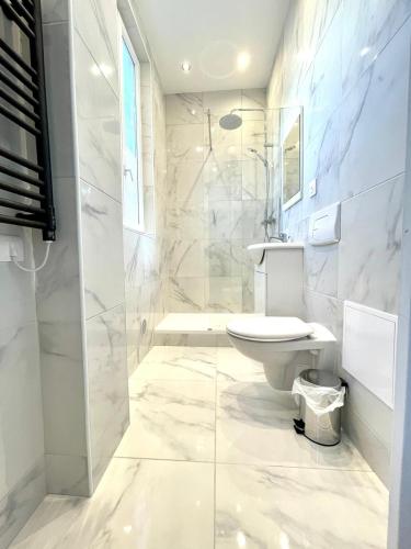 une salle de bain blanche avec des toilettes et un lavabo dans l'établissement Appartement 2 pièces tout équipé très lumineux, à Nanterre