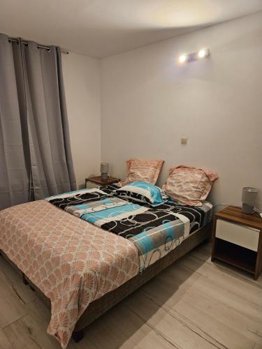 Schlafzimmer mit einem Bett und einem Beistelltisch in der Unterkunft Grand Appartement cosy et lumineux in Mons