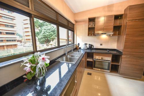 a kitchen with a sink and a large window at Speke Apartments Wampewo in Kampala