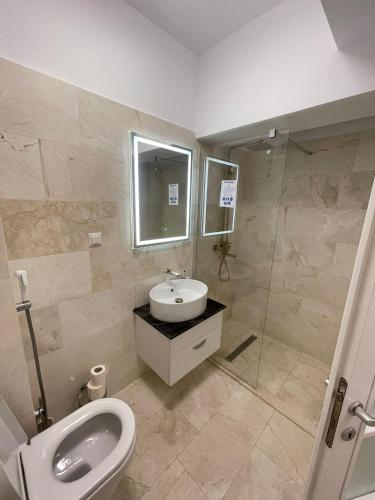 a bathroom with a toilet and a sink and a shower at Capodopera Residence in Iaşi
