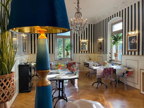 un comedor con mesas y una gran lámpara azul en Hotel Villa Herzog, en Dresden