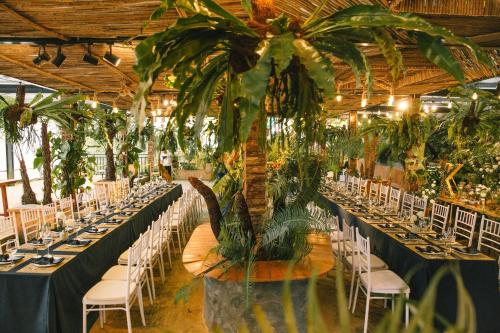a banquet hall with tables and chairs with plants at Cloud9 Glamping & Cafe in Xuân Trường