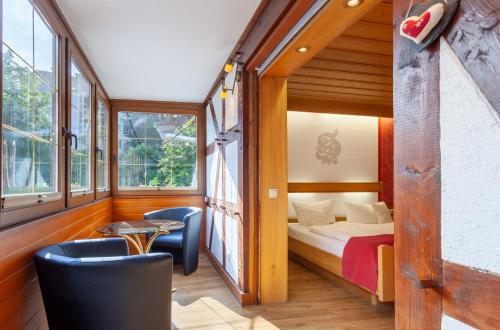 um quarto com uma cama, duas cadeiras e uma mesa em Hotel Sauerländer Hof em Willingen