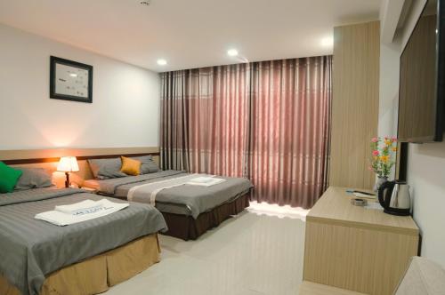 ein Hotelzimmer mit 2 Betten und einem Fenster in der Unterkunft Melody Hotel in Nha Trang