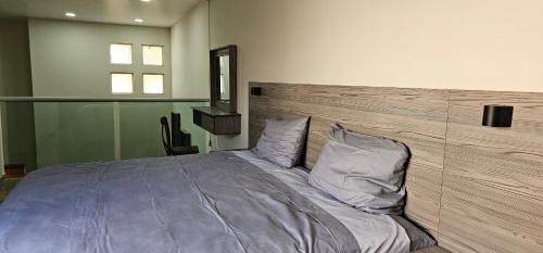- une chambre avec un grand lit et une tête de lit en bois dans l'établissement Privanza, à Guadalajara