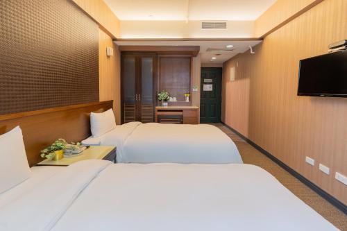 a hotel room with two beds and a flat screen tv at CHECK inn Express Taichung Fengchia in Taichung