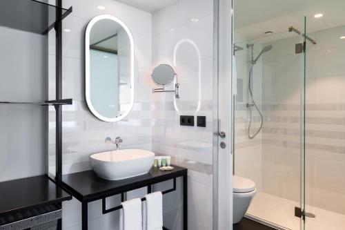 a white bathroom with a sink and a shower at Residence Inn by Marriott Ghent in Ghent