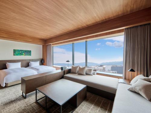 une chambre d'hôtel avec deux lits et un canapé dans l'établissement The Royal Park Canvas Fukuoka Nakasu, à Fukuoka