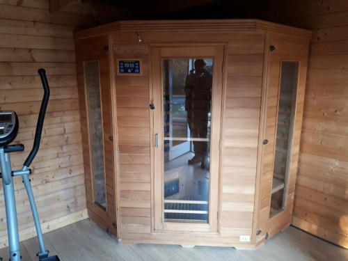 a wooden sauna with a glass door in a room at Villa Marcel Spa Sauna Billard Piscine 25mn de Bordeaux in Cérons