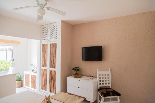 ein Wohnzimmer mit einem TV an der Wand in der Unterkunft VR CLUB Tulum Riviera in Tulum
