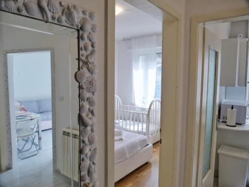 格拉多FIORE DI MARE - Delizioso bilocale con posto auto vicino al porto的镜子在一个带婴儿床的房间和一间卧室