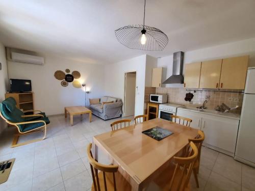 eine Küche und ein Wohnzimmer mit einem Tisch und Stühlen in der Unterkunft Le Salvador - maisonnette pour 4 in Sigean