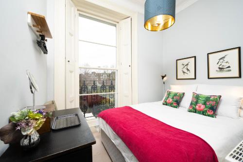 a bedroom with a bed and a desk with a laptop at Charming Apartment in the Heart of Camden in London