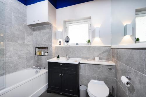 a bathroom with a sink and a toilet and a tub at Charming Apartment in the Heart of Camden in London