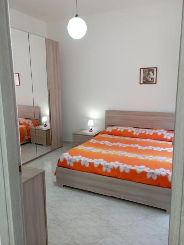 una camera da letto con un letto con lenzuola bianche e arancioni di Sardinia ovest a Oristano