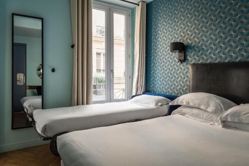 - une rangée de lits dans une chambre avec fenêtre dans l'établissement Hotel Elysée Etoile, à Paris