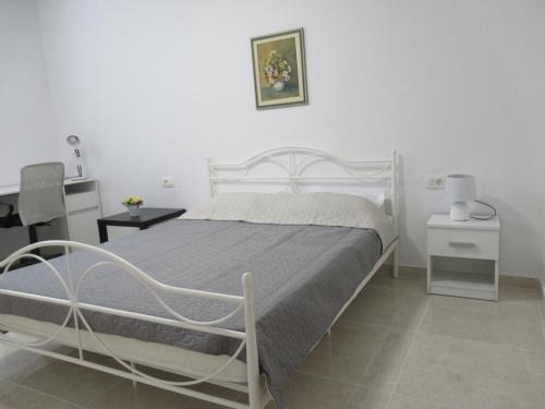 a bedroom with a white bed and a desk at Relax Beach Apartment in Split