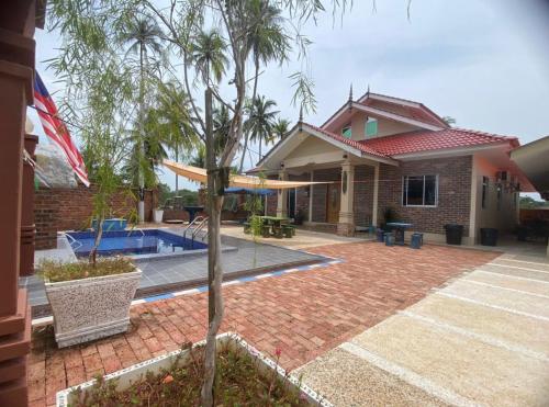 ein Haus mit einem Pool im Hof in der Unterkunft Sand Dune Villa in Kampong Beting Lintang
