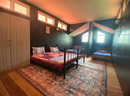 a bedroom with a bed and a table and windows at Sand Dune Villa in Kampong Beting Lintang