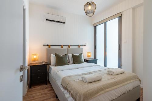a bedroom with a large bed with two towels on it at Latte's Prime 1-Bedroom Apartment in Larnaca in Larnaca