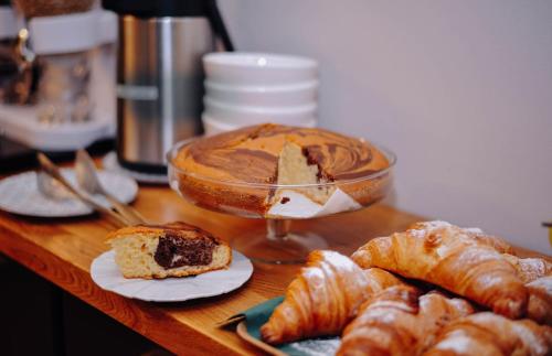 a table with pastries and a bowl of chocolate pudding and croissants at HOTEL ANGEL SOFIA in Fălticeni