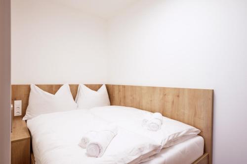 a bed with white towels on top of it at Alpenstolz Damüls Haus 2 - Stilvoll urlauben in den Bergen in Damuls