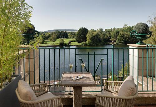 a balcony with a table and chairs and a view of a lake at La Côte Saint Jacques in Joigny