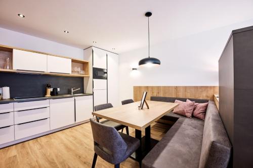 uma cozinha e sala de estar com um sofá e uma mesa em Alpenstolz Damüls Haus 2 - Stilvoll urlauben in den Bergen em Damüls