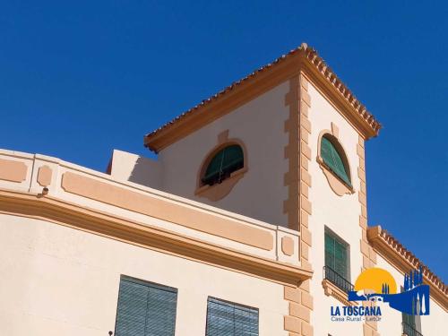 a building with a tower with two windows on it at La Toscana de Letur in Letur