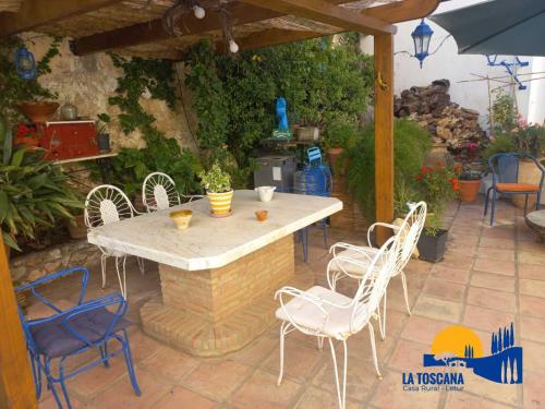 a patio with a table and chairs and an umbrella at La Toscana de Letur in Letur