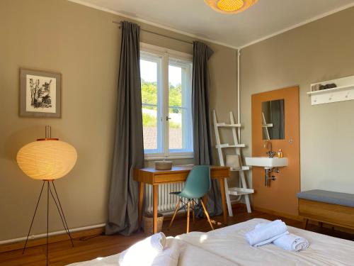 Schlafzimmer mit einem Bett, einem Schreibtisch und einem Fenster in der Unterkunft Exklusives Ferienhaus in Top Lage: Der Johannishof in Würzburg