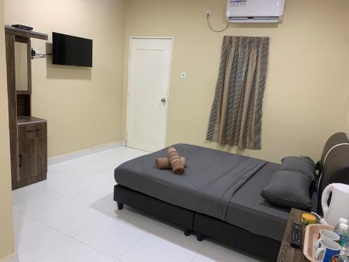 um quarto com uma cama com um urso de peluche em Maze Roomstay Langkawi em Pantai Cenang