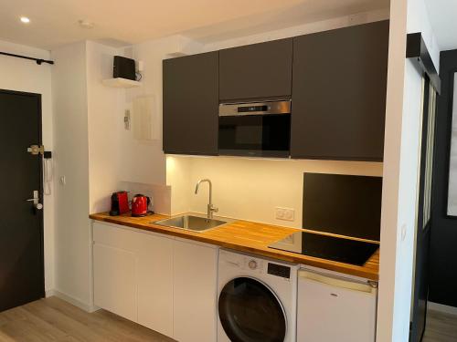 uma cozinha com uma máquina de lavar roupa e um lavatório em Grand Studio - Strasbourg em Estrasburgo