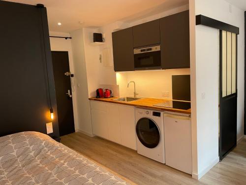 uma cozinha com uma máquina de lavar roupa e um lavatório em Grand Studio - Strasbourg em Estrasburgo