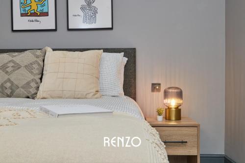 a bedroom with a bed with a lamp on a night stand at Stunning 1-bed Apartment in Derby by Renzo, Free Wi-Fi, Sofa Bed, Sleeps 3! in Derby