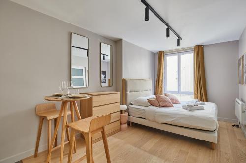 une chambre avec un lit, une table et un miroir dans l'établissement Studio Tour Eiffel by Studio prestige, à Paris
