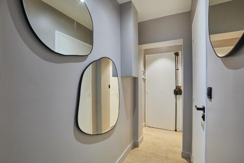 un couloir avec deux miroirs sur un mur dans l'établissement Studio Tour Eiffel by Studio prestige, à Paris
