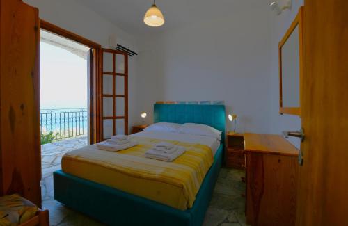 a bedroom with a bed and a desk and a window at Secret Sporades Panoramic Residence in Klíma