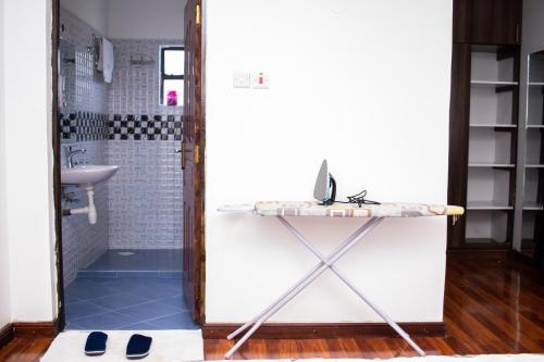 a bathroom with a console table and a sink at The Country Side Villa - Nanyuki in Nanyuki