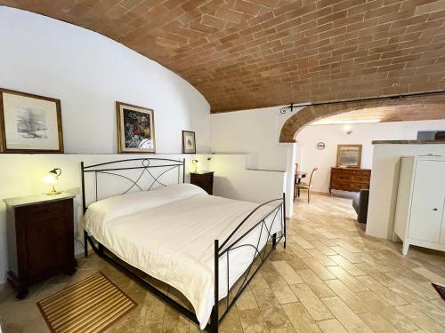 a bedroom with a bed and a brick wall at Fonte 6: Centro vicino piazza del Campo in Siena