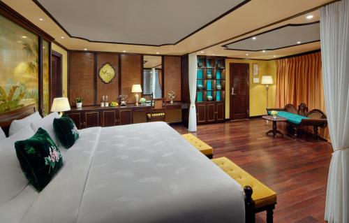 a bedroom with a large bed and a living room at Indochine Premium Halong Bay in Ha Long