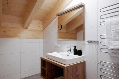 a bathroom with a sink and a mirror at Alpenstolz Damüls Haus 2 - Stilvoll urlauben in den Bergen in Damuls