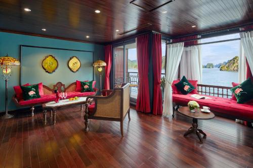 a living room with red couches and a view of the water at Indochine Premium Halong Bay in Ha Long