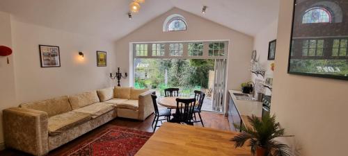a living room with a couch and a table at Peaceful Getaway in Forested Park in Bournemouth
