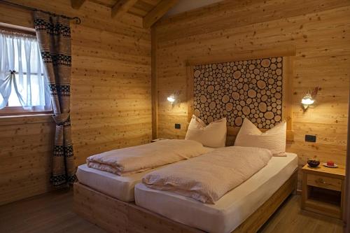 a bedroom with a bed in a wooden room at Chalet Camping Faè 4 - Trilocale in Madonna di Campiglio