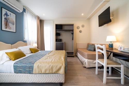 a hotel room with a bed and a desk with a computer at Hotel Rivage Taormina in Taormina
