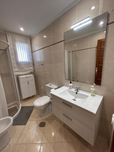 a bathroom with a sink and a toilet and a mirror at Apartamento en Los Cristianos in Los Cristianos