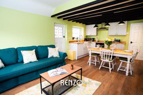 a living room with a blue couch and a table at Homely 1-bed Cottage in Stoke Bardolph, Nottingham by Renzo, Stunning Countryside Location! in Burton Joyce